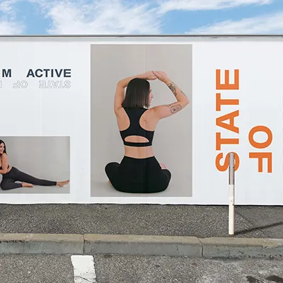 Outdoor hoarding mockup with models in black SOM Active activewear and 'State of Mind' in bold orange type